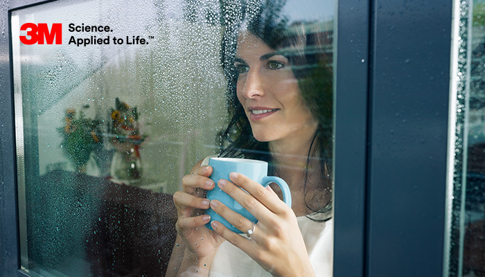 Lady standing right next to her window because of 3M thinsulate window film